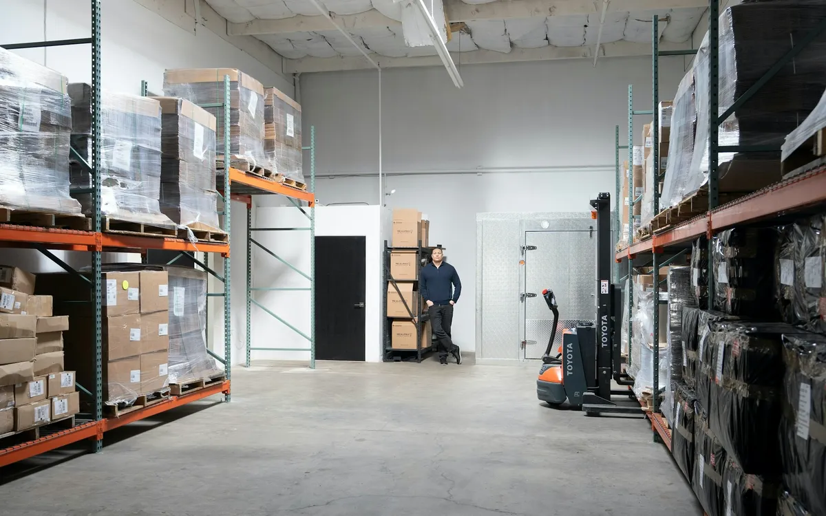 Paletli raf sistemleri ve forklift bulunan aydınlık bir depo iç mekânı