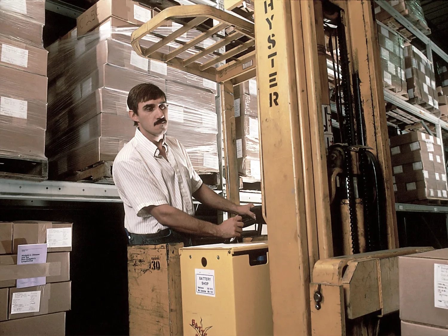 Paletli raflar arasında forkliftle çalışılan bir depo